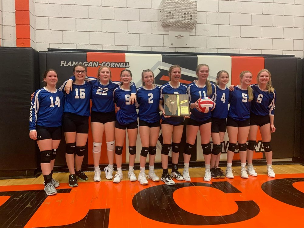 Volleyball girls hold championship plaque in gym
